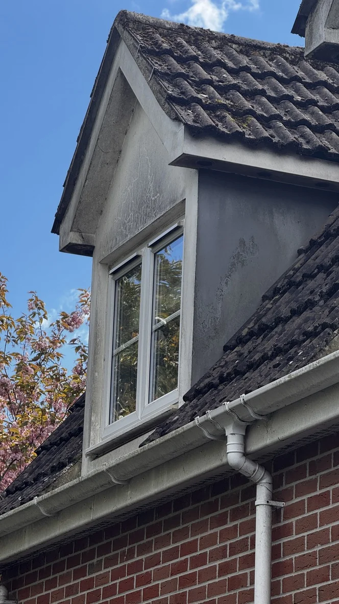 Dirty, stained render around a dormer window before cleaning, at a home in Chippenham