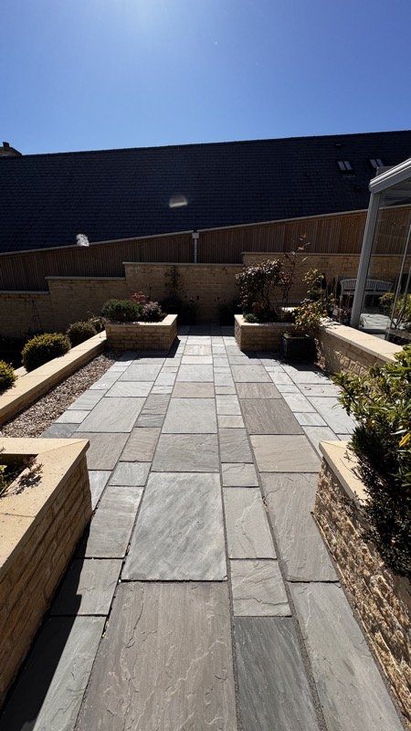 The same patio after cleaning, with clean, light grey paving