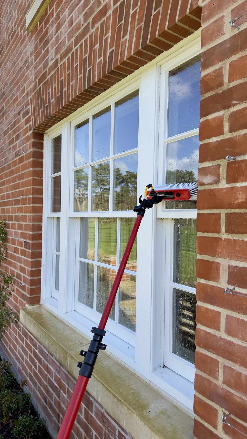 Cleaning a large multi-pane window with a pole