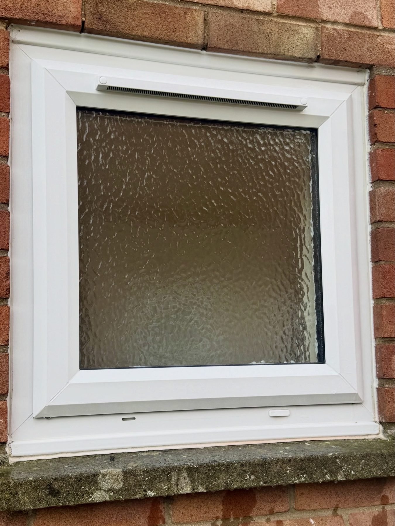 The same obscured-glass window after cleaning, with a clean white frame