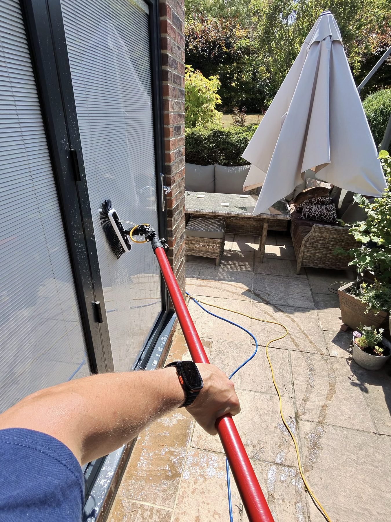 Cleaning patio doors with a pole and brush